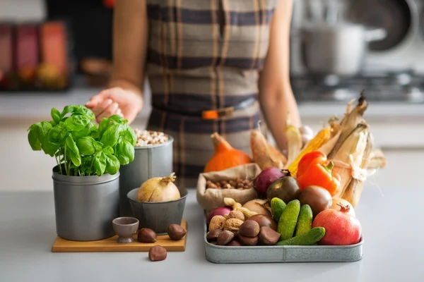 Nahaufnahme einer jungen Hausfrau mit Gemüse in der Küche — Stockfoto