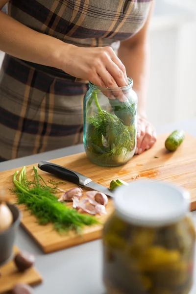 Close-up op jonge huisvrouw beitsen komkommers — Stockfoto