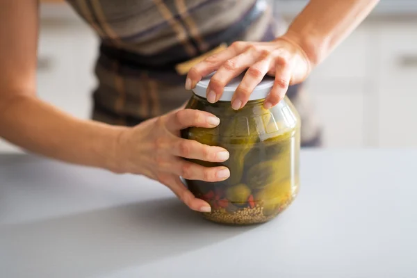 Gros plan sur jeune femme au foyer ouverture pot de concombres marinés — Photo