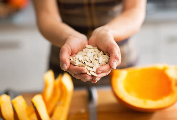 Närbild på ung hemmafru visar pumpafrön — Stockfoto