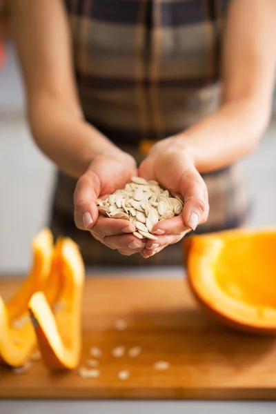 Primer plano de ama de casa joven mostrando semillas de calabaza — Foto de Stock