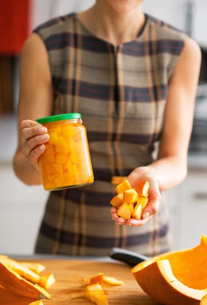 Gros plan sur la jeune femme au foyer montrant pot de citrouille marinée et pu — Photo