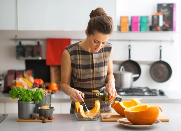 Junge Hausfrau kocht Kürbis in Küche — Stockfoto