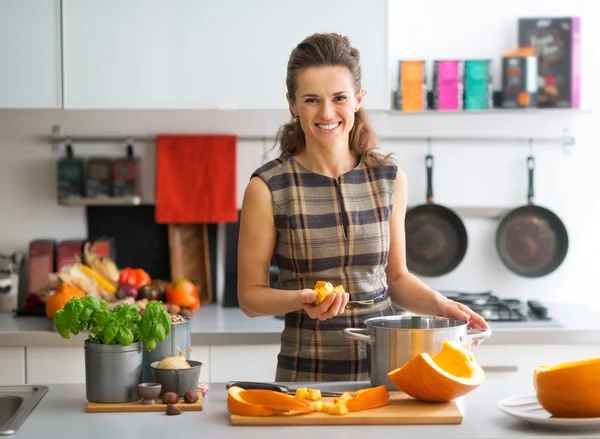 Portrait of happy young housewife cooking pumpkin — Stock Photo, Image