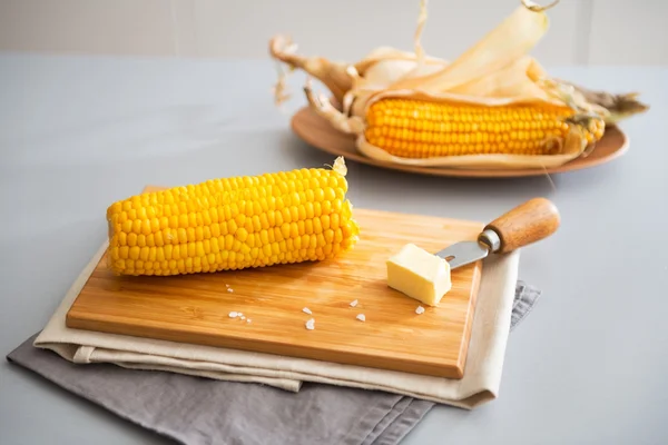 Fechar em milho cozido e manteiga na tábua de corte — Fotografia de Stock