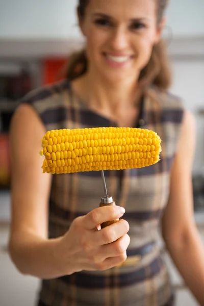 Closeup on young woman showing boiled corn — Stock Photo, Image