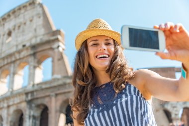 Gülümseyen genç kadın selfie colosseum önünde Roma'da yapmak,