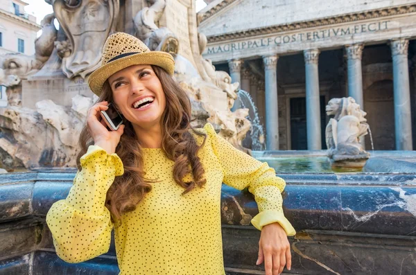 Portret van lachende jonge vrouw praten mobiele telefoon in de buurt van fontein — Stockfoto