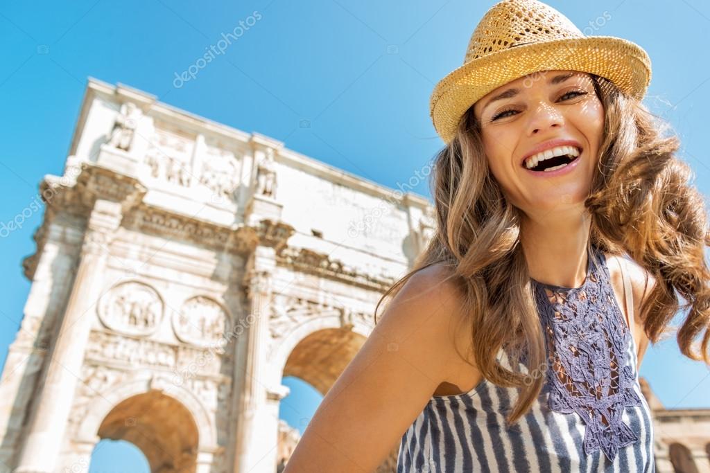 Portrait of happy young woman near arch of constantine in rome, 