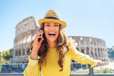 Genç kadın konuşan cep telefonu colosseum önünde gülümseyen