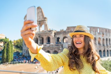 Gülümseyen genç kadın col önünde cep telefonu ile fotoğraf çekme