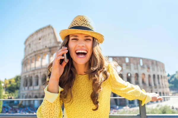 Sonriente mujer joven hablando de teléfono celular frente al coliseo en —  Fotos de Stock