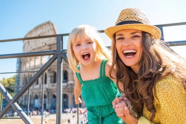 Porträtt av lycklig mor och baby flicka framför colosseum i — Stockfoto