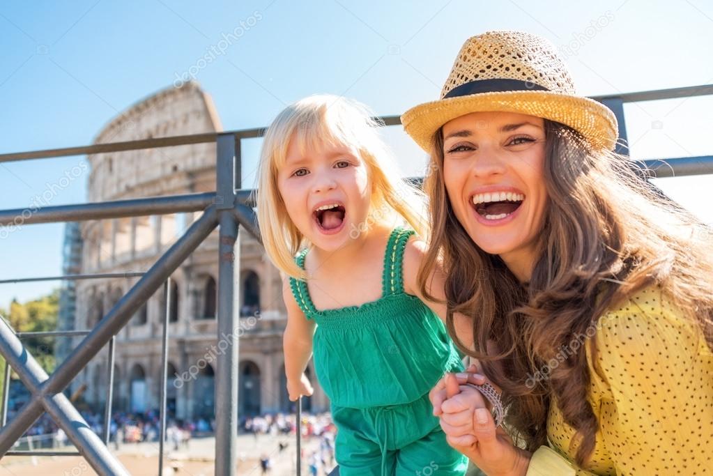 Portrait of happy mother and baby girl in front of colosseum in 