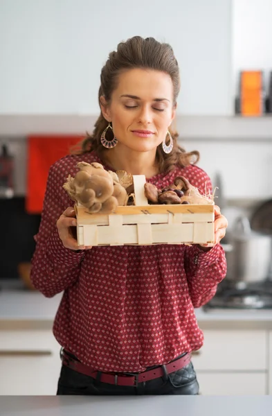 Young housewife enjoying freshness of mushrooms in basket — Stock Photo, Image