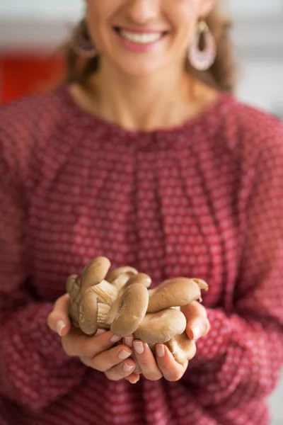 Closeup on young housewife showing oyster mushrooms — Stock Photo, Image