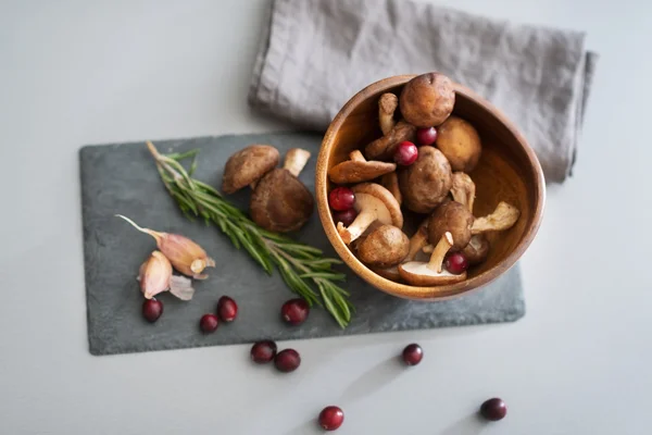 Closeup on mushrooms lingonberries and rosmarinus on table — Stock Photo, Image