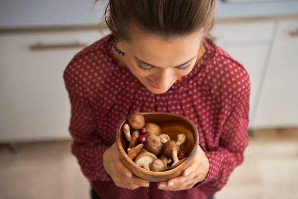 Jonge huisvrouw houden plaat met champignons — Stockfoto