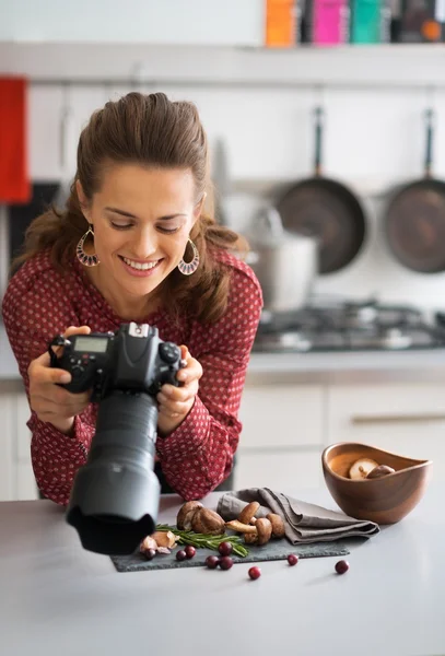 Щаслива жінка-продовольчий фотограф перевіряє фотографії в камері — стокове фото