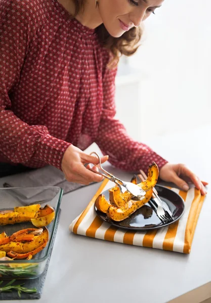 Primer plano de la joven ama de casa sirviendo calabaza al horno — Foto de Stock