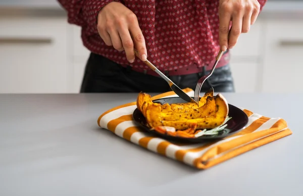 Primer plano de ama de casa joven comiendo calabaza al horno — Foto de Stock