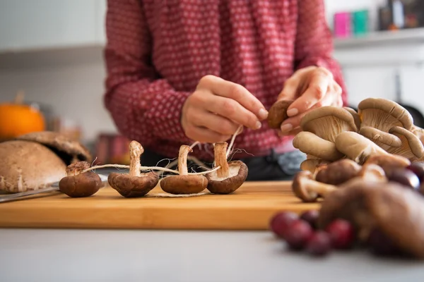 Closeup on young housewife stringing mushrooms on string — Stock Photo, Image