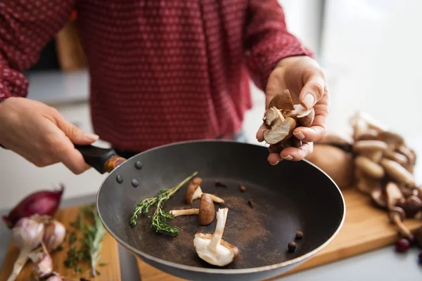 Primo piano sulla giovane casalinga che cucina funghi — Foto Stock