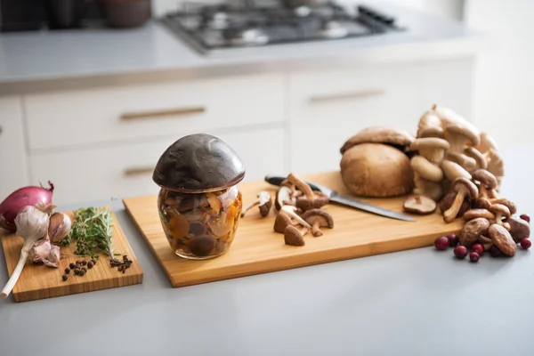 Closeup on jar of pickled mushroom on cutting board — Stock Photo, Image