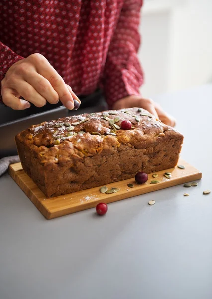 Closeup on young housewife decorating freshly baked pumpkin brea — Stock Photo, Image