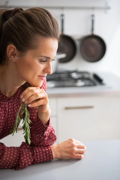 Mladá hospodyňka s čerstvým rosmarinus v kuchyni — Stock fotografie