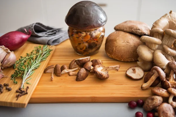 Closeup on jar of pickled mushroom on cutting board — Stock Photo, Image