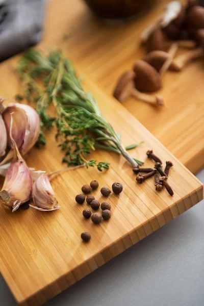 Close-up op peper knoflook en rosmarinus op snijplank — Stockfoto