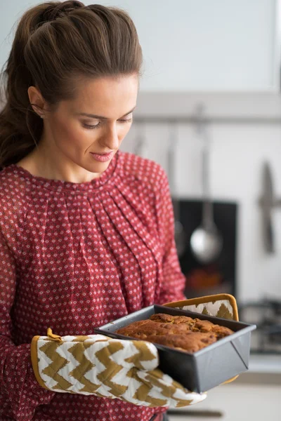 Jonge huisvrouw met bakken schotel met brood — Stockfoto