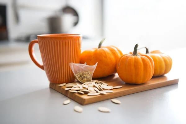 Closeup on small pumpkins seeds and tea bag on table — Stock Photo, Image