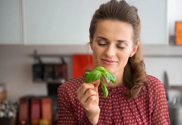 Jonge huisvrouw genieten van verse basilicum — Stockfoto