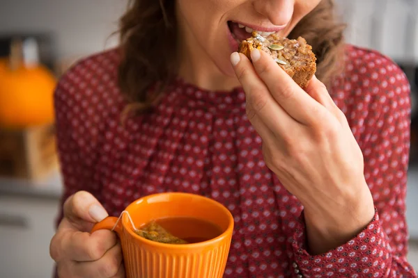 Nahaufnahme einer jungen Hausfrau, die Tee mit frisch gebackenem Kürbis trinkt — Stockfoto