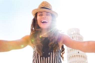 Happy young woman making selfie in front of leaning tower of pis clipart