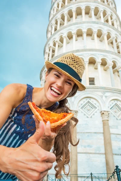 Young woman with pizza showing thumbs up in front of leaning tow — Stock Photo, Image