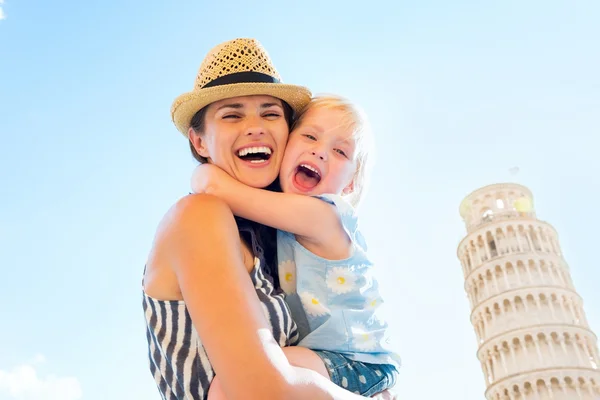 Šťastná matka a holčička objímání před šikmá věž — Stock fotografie