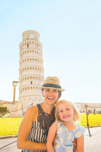 Portret van gelukkige moeder en babymeisje voor scheve toren — Stockfoto