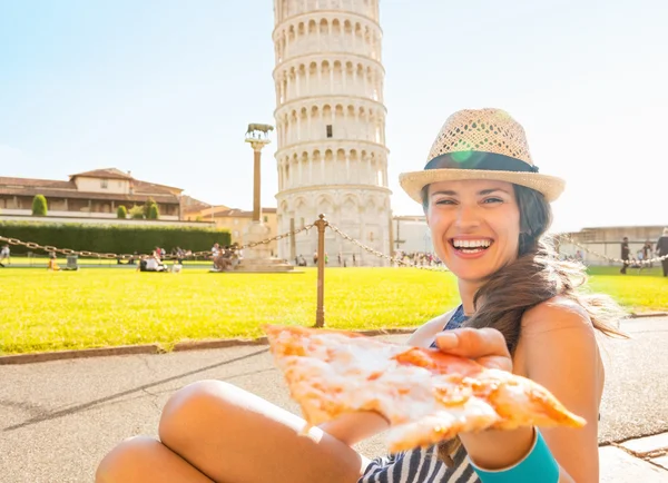 Young woman giving pizza in front of leaning tower of pisa, tusc — Stock Photo, Image