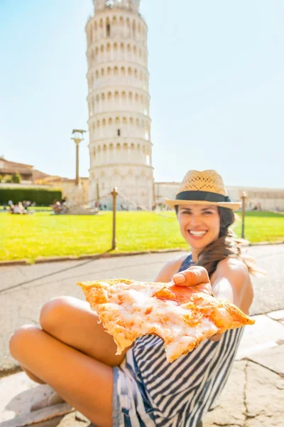 Крупный план молодой женщины, дающей пиццу перед наклоном башни — стоковое фото