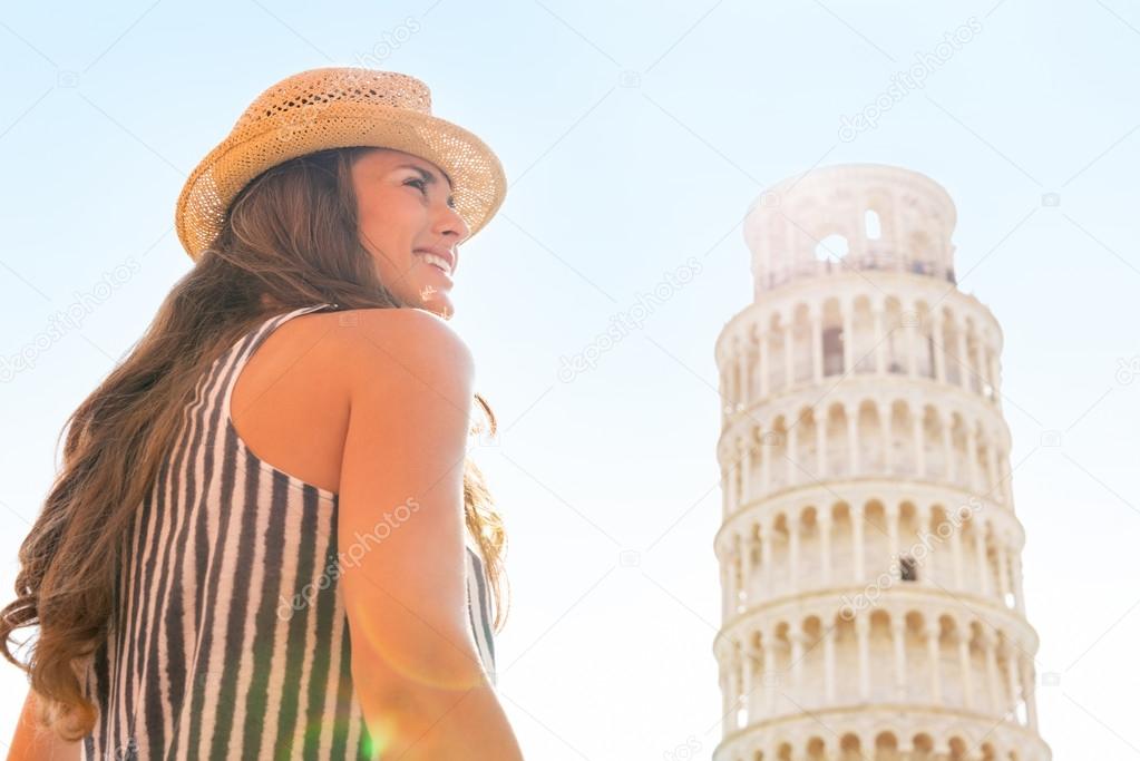 Happy young woman in front of leaning tower of pisa, tuscany, it