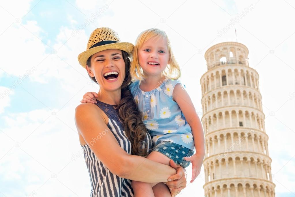 Portrait of happy mother and baby girl in front of leaning tower