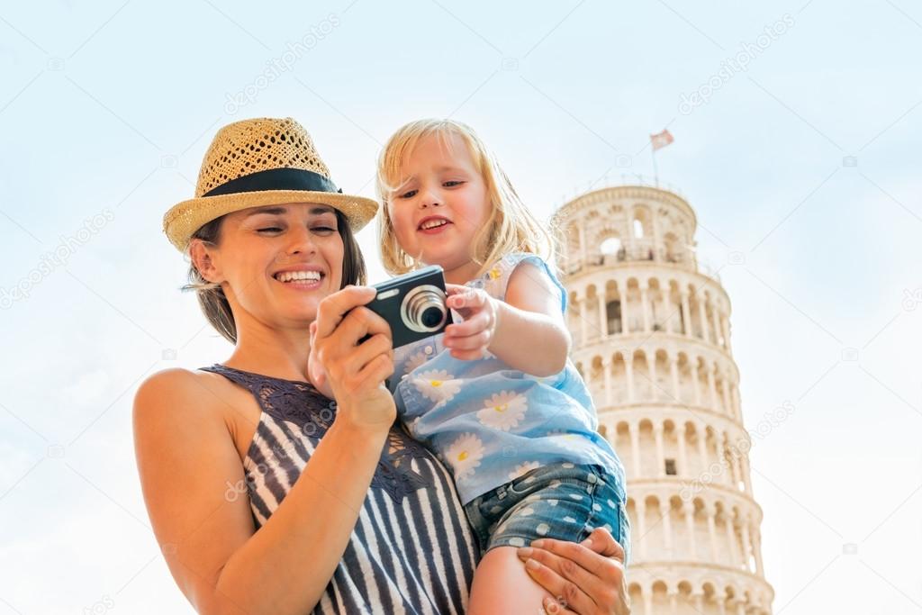 Portrait of happy mother and baby girl checking photos in camera