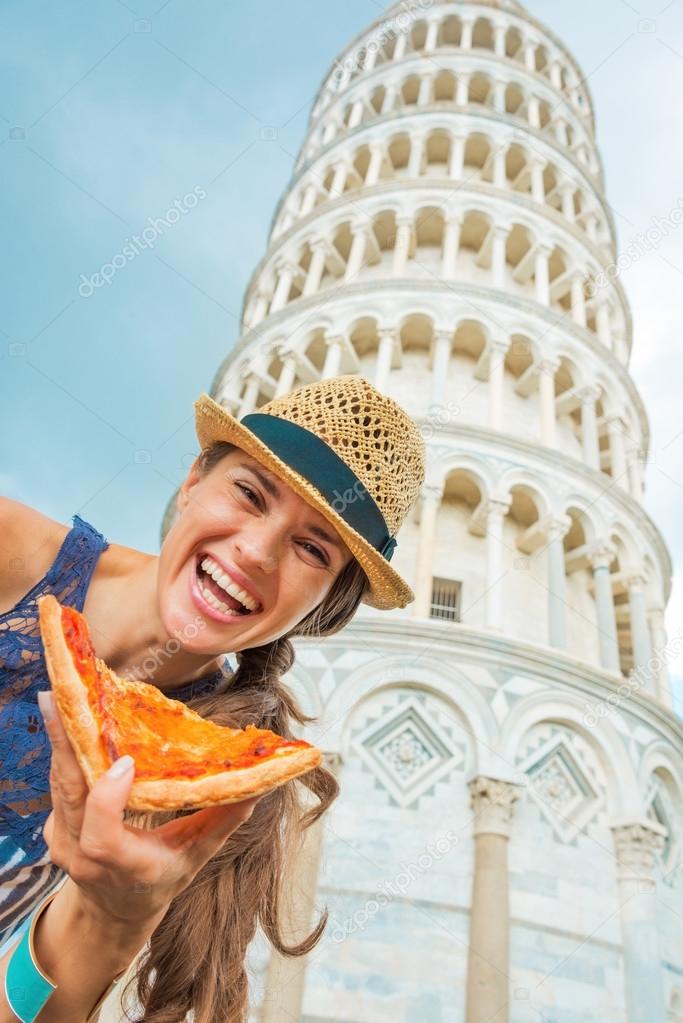 Happy young woman with pizza in front of leaning tower of pisa, 