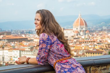 Happy young woman against panoramic view of florence, italy clipart