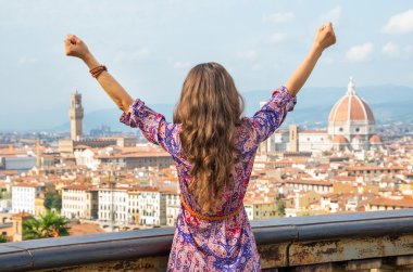 Young woman rejoicing against panoramic view of florence, italy