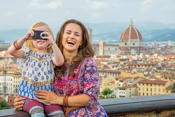 Счастливая мать и маленькая девочка фотографируются на фоне панорамы — стоковое фото