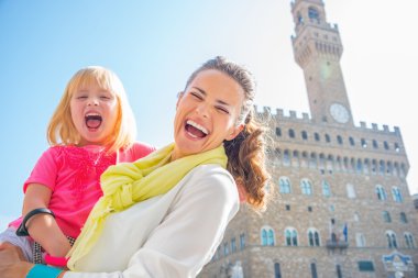Gülümseyen anne ve bebek kız palazzo vec önünde portresi